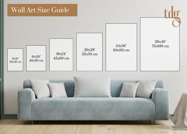 May include: Wall art size guide with different sizes of white frames displayed on a white wall above a light blue sofa. The sizes are listed in inches and centimeters. The text "Wall Art Size Guide" is at the top of the image.