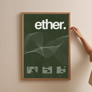 May include: A framed art print with the word "ether" in white, over a dark green background. The print features a white, wavy line design and text describing the unseen fabric of existence. The frame is a light brown color.