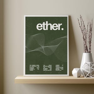May include: A framed art print with the word "ether." in white, set against a dark green textured background. A white, wavy line design is featured below the text. The print is displayed on a wooden shelf with decorative items.