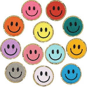 May include: Twelve embroidered smiley face patches in various colors, including pink, red, yellow, green, purple, orange, light pink, light blue, gray, and blue. Each patch has a gold glitter outline.
