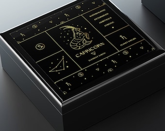 May include: Black wooden box with a gold design featuring the zodiac sign Capricorn and the text "CAPRICORN". The box is open and the inside is lined with white felt.