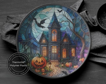 Puede incluir: Un plato de cena de Halloween negro y azul con un diseño de vitral de una casa encantada con una calabaza tallada en frente. El plato está hecho de plástico de polímero ThermoSaf y es seguro para usar en el microondas y el lavavajillas.