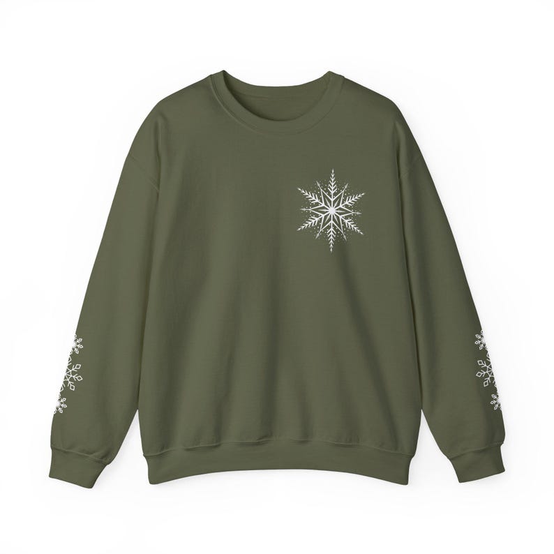 May include: A green sweatshirt with a white snowflake design on the front and white snowflakes on the sleeves.