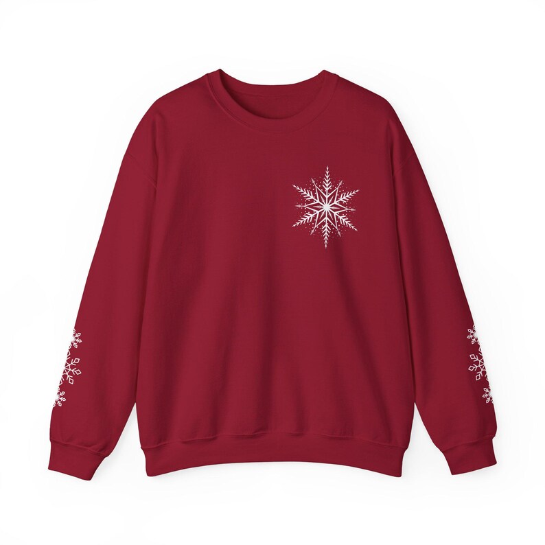 May include: A red sweatshirt with a white snowflake design on the front and smaller snowflakes on the sleeves.