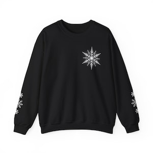 May include: Black sweatshirt with a white snowflake design on the front and white snowflakes on the sleeves.