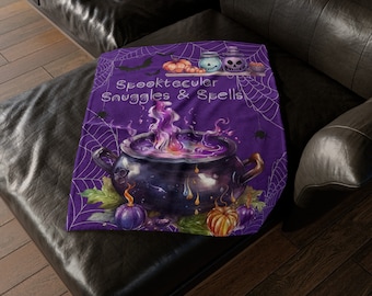 May include: Purple Halloween themed throw blanket with a cauldron, pumpkins, and bats. The text reads "Spooktacular Snuggles & Spells".