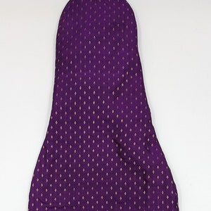 May include: A purple fabric bag with a gold diamond pattern. The bag is empty and has a drawstring closure.