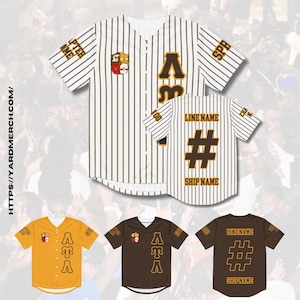 Op de afbeelding: Wit en bruin gestreept baseballshirt met een Grieks letterontwerp en een wapenschild op de linkerborst. Het shirt heeft een nummer en tekst op de rug. Er zijn ook drie andere shirts op de afbeelding: een gele, een bruine en een witte met een nummer en tekst op de rug.