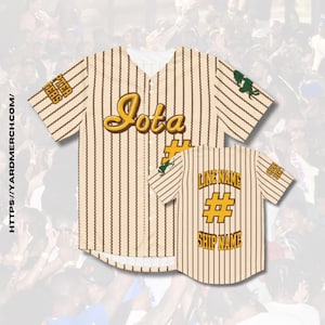 Puede incluir: Una camiseta de béisbol de color crema con rayas marrones y un "Jota" dorado en la parte delantera. La parte posterior de la camiseta tiene un diseño dorado "LINE NAME # SHIP NAME".