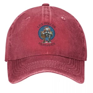 May include: A red vintage baseball cap with a white embroidered logo featuring two cartoon chickens with the text "Los Pollos Hermanos".