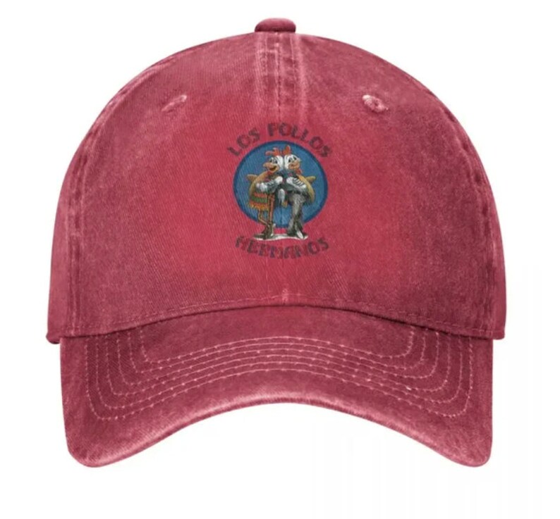 May include: A red vintage baseball cap with a white embroidered logo featuring two cartoon chickens with the text "Los Pollos Hermanos".