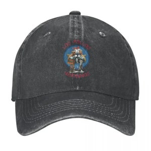 May include: A black distressed denim baseball cap with a vintage-style logo featuring two cartoon chickens holding fish and the text "Los Pollos Hermanos".