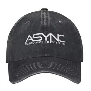 Peut inclure: Une casquette de baseball noire avec une finition délavée et usée. L'avant présente le texte brodé en blanc ASYNC RESEARCH INSTITUTE dans une police sans empattement. La casquette a une visière incurvée avec des coutures et des œillets.