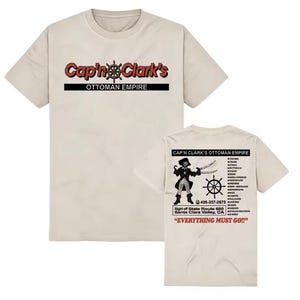 Peut inclure: Un t-shirt beige à manches courtes avec le texte Cap'n Clark's Ottoman Empire sur le devant. Le dos présente un graphique de pirate, une roue de navire, une liste de meubles, un numéro de téléphone, des détails de lieu et le texte EVERYTHING MUST GO.
