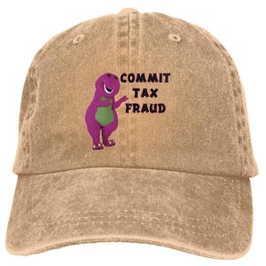 Op de afbeelding: Een beige, verweerde baseballpet met een paarse dinosaurusfiguur en de tekst "COMMIT TAX FRAUD" op de voorkant.