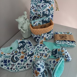 Peut inclure: Un ensemble d'articles pour bébé dans un motif floral bleu et blanc avec des renards, des oiseaux et des fleurs. L'ensemble comprend une bavette, une serviette à langer, un chapeau et un ensemble de disques démaquillants réutilisables dans un panier en tissu.