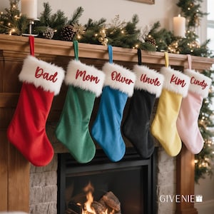 May include: A collection of six Christmas stockings in various colors, including red, green, blue, black, yellow, and pink. Each stocking has a white faux fur cuff and a name embroidered in red. The stockings are hanging above a fireplace.