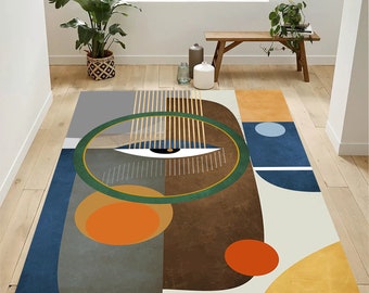 May include: Abstract geometric rug with a brown, green, blue, orange, and yellow color scheme. The rug features a large eye design with a white iris and black pupil.
