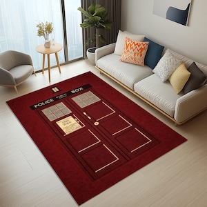 May include: A rectangular burgundy rug with the design of a blue police box, a recognizable feature from a science fiction series. The rug has the words "POLICE PUBLIC CALL BOX" at the top and a sign that reads "FREE FOR USE PULL TO OPEN".