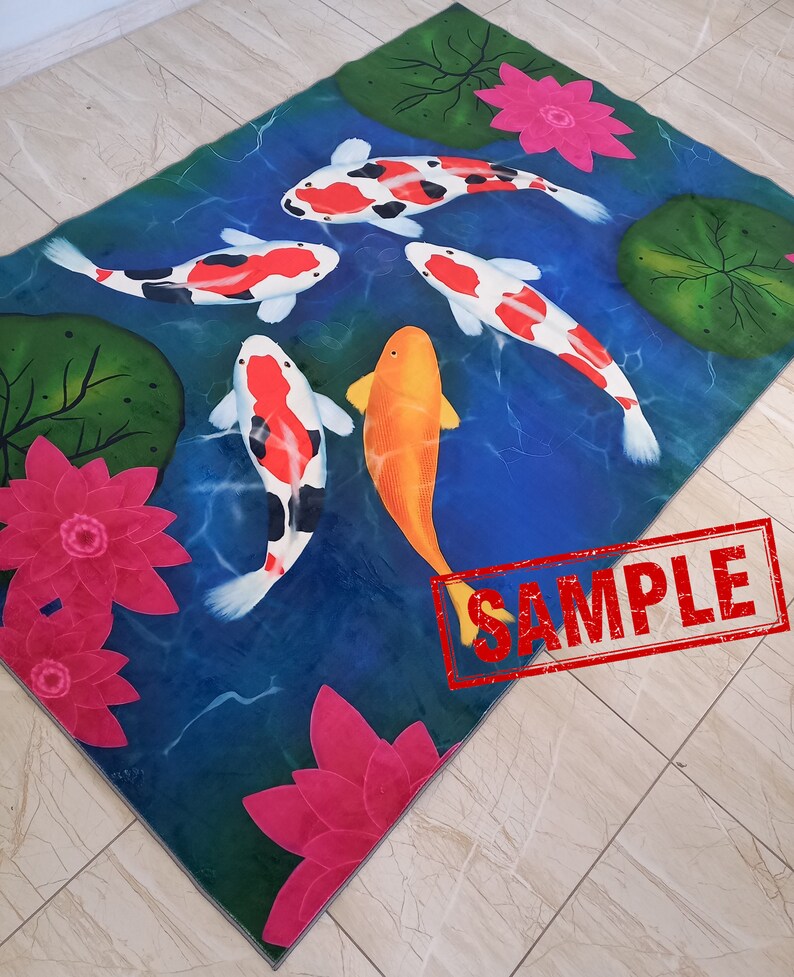May include: A rectangular rug featuring a pond scene with koi fish and water lilies. The koi fish are orange, white, and black, swimming in blue water. Pink water lilies and green lily pads are also present. The word "SAMPLE" is stamped on the rug.