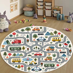 May include: A round area rug featuring a colorful illustrated road map with various vehicles including police cars, fire trucks, buses, and construction trucks, interspersed with trees, houses, traffic lights, and stop signs on a light background.