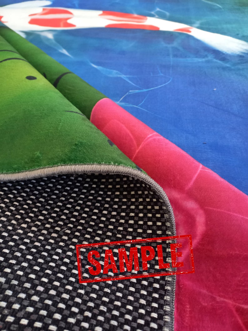 May include: Rolled-up rug with a koi fish design. The rug features a vibrant color palette, including shades of green, pink, and blue. The underside of the rug has a black and white checkered pattern. The word "SAMPLE" is stamped on the rug.