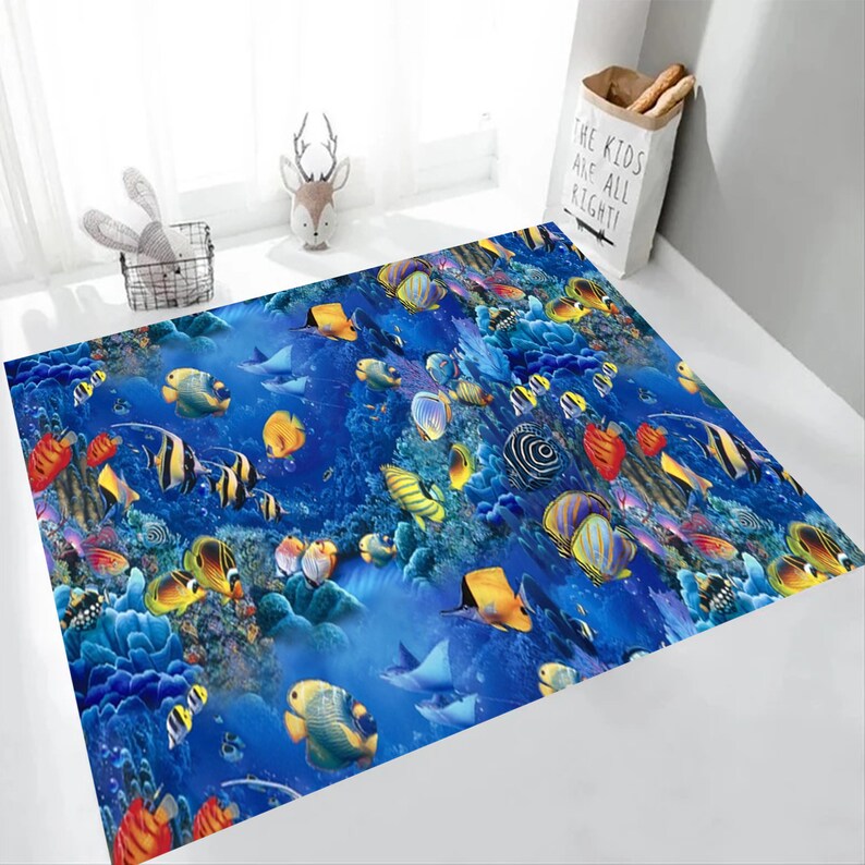 May include: A rectangular area rug featuring a vibrant underwater scene. The rug showcases a deep blue background with colorful fish, coral, and rays. The design creates a lively and immersive aquatic environment.
