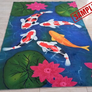 May include: A rectangular rug featuring a pond scene with koi fish and water lilies. The koi fish are white, orange, and black, swimming in blue water. Pink water lilies and green lily pads are also present. The word "SAMPLE" is stamped on the rug.