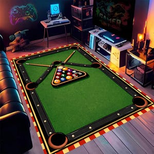 May include: A rectangular area rug designed to resemble a pool table. The rug features a green playing surface, black borders with faux pockets, and a red and white striped edge. A triangle of billiard balls and two cues are on the rug.
