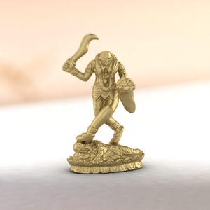 Puede incluir: Una estatua dorada de una deidad, sosteniendo una cuchilla curva en una mano y un escudo en la otra. La figura está de pie sobre una base detallada y ornamentada. La estatua está representada en un estilo realista, con detalles intrincados.