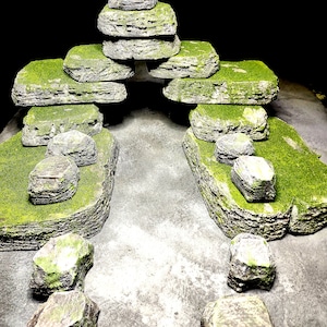 Puede incluir: Una formación rocosa cubierta de musgo con un arco de piedra apilado en el centro. Las rocas son grises y verdes con un musgo verde claro que las cubre.