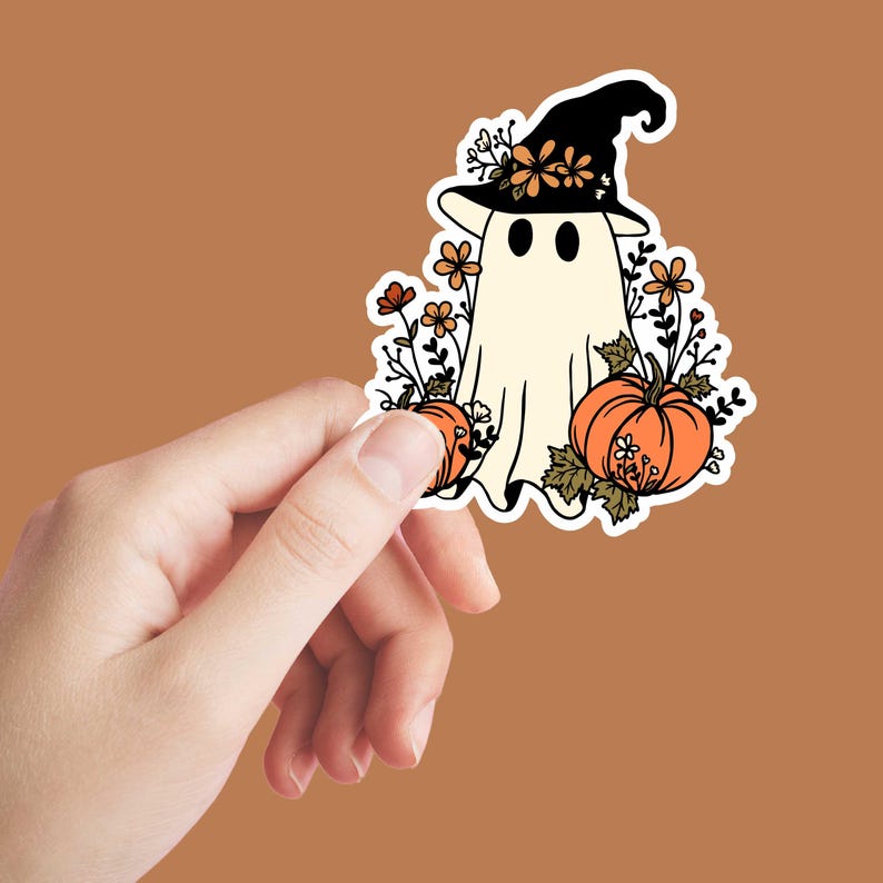 May include: A white ghost wearing a witch hat with flowers and pumpkins. The ghost is surrounded by flowers and leaves.
