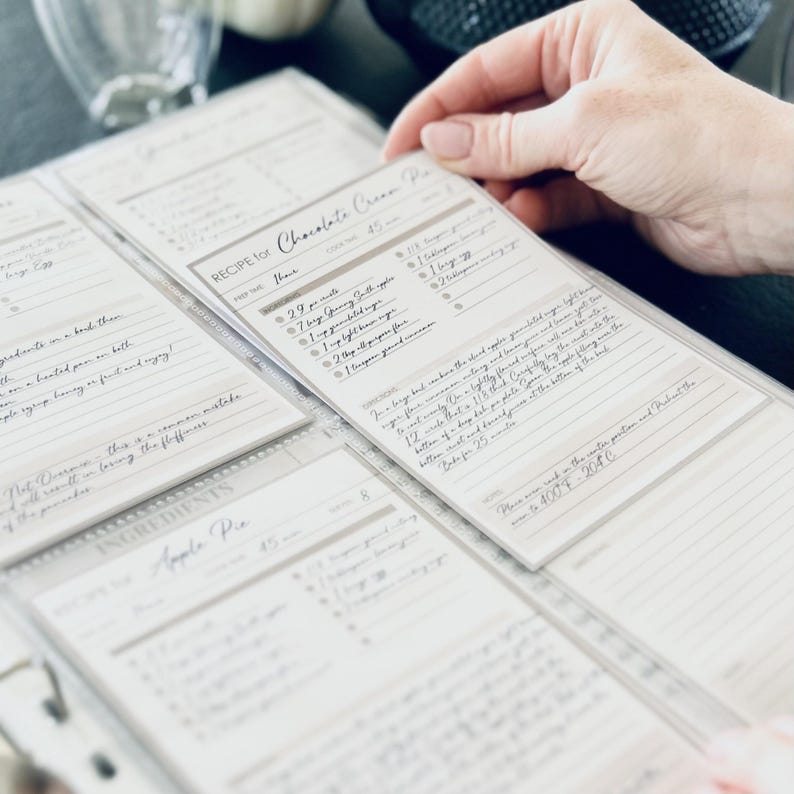 Personalized custom ring binder recipe book with hard cover and printed pages. Features recipe journal pages with sections for recipe name, prep time, cook time, servings, ingredients, directions, and notes. Includes 16 category dividers, 10 notes pages, 20 transparent sleeves, and one clear envelope sheet for small notes. Perfect for saving cherished meals, holiday dishes, and family traditions — a thoughtful gift for home cooks who love sharing meals together.