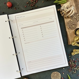 Personalized custom ring binder recipe book with hard cover and printed pages. Features recipe journal pages with sections for recipe name, prep time, cook time, servings, ingredients, directions, and notes. Includes 16 category dividers, 10 notes pages, 20 transparent sleeves, and one clear envelope sheet for small notes. Perfect for saving cherished meals, holiday dishes, and family traditions — a thoughtful gift for home cooks who love sharing meals together.