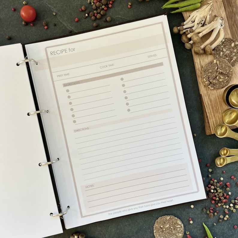 Personalized custom ring binder recipe book with hard cover and printed pages. Features recipe journal pages with sections for recipe name, prep time, cook time, servings, ingredients, directions, and notes. Includes 16 category dividers, 10 notes pages, 20 transparent sleeves, and one clear envelope sheet for small notes. Perfect for saving cherished meals, holiday dishes, and family traditions — a thoughtful gift for home cooks who love sharing meals together.