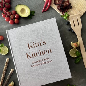 Handcrafted Light gray cover color with foil copper lettering color personalized recipe book and binder, covered in soft fabric and made with high-quality materials. Designed to organize and preserve handwritten family recipes, this elegant cookbook serves as a timeless keepsake. Perfect for saving cherished meals, holiday dishes, and family traditions, it makes a thoughtful and lasting gift for home cooks who treasure the joy of sharing meals together.