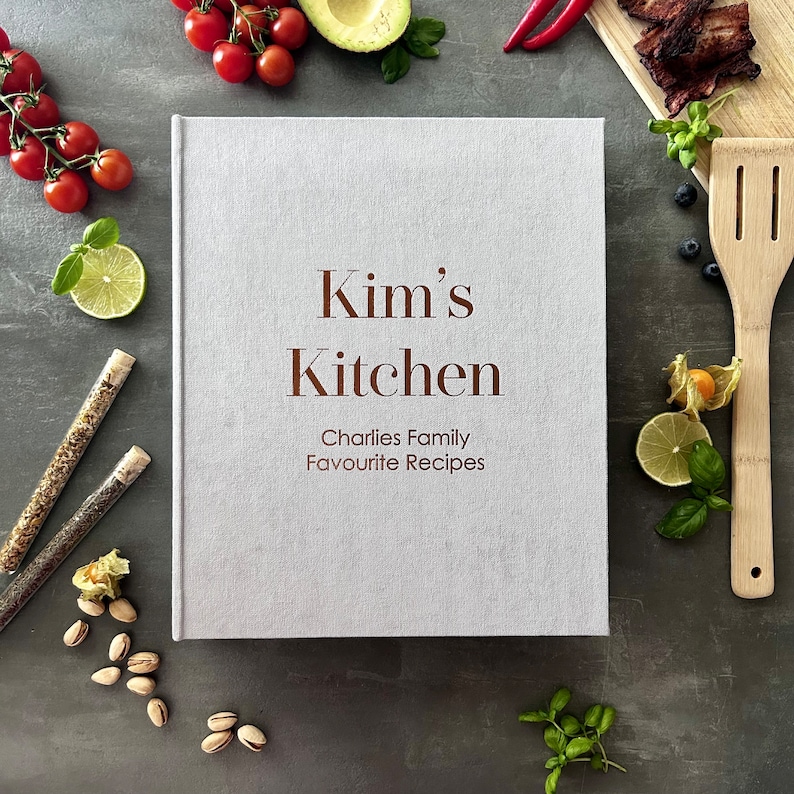 Handcrafted Light gray cover color with foil copper lettering color personalized recipe book and binder, covered in soft fabric and made with high-quality materials. Designed to organize and preserve handwritten family recipes, this elegant cookbook serves as a timeless keepsake. Perfect for saving cherished meals, holiday dishes, and family traditions, it makes a thoughtful and lasting gift for home cooks who treasure the joy of sharing meals together.