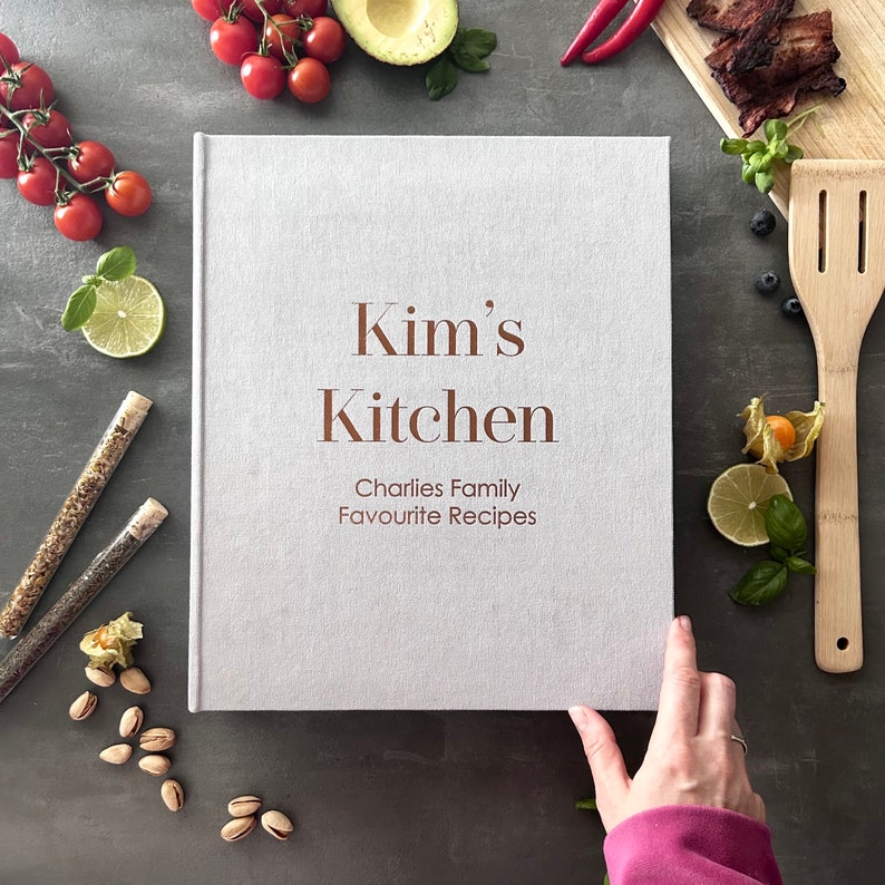 Handcrafted Light gray cover color with foil copper lettering color personalized recipe book and binder, covered in soft fabric and made with high-quality materials. Designed to organize and preserve handwritten family recipes, this elegant cookbook serves as a timeless keepsake. Perfect for saving cherished meals, holiday dishes, and family traditions, it makes a thoughtful and lasting gift for home cooks who treasure the joy of sharing meals together.