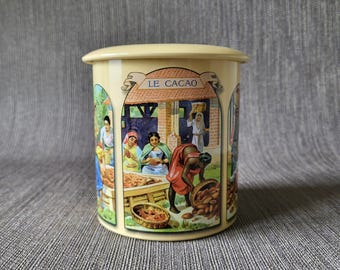 Lata de almacenamiento vintage Le Cacao con ilustraciones botánicas y de paisajes.