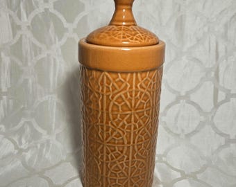 Tarro de cerámica color terracota con tapa.