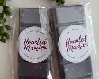 May include: Two wax melts in clear packaging with a black and gray color scheme. The wax melts are labeled "Haunted Mansion" and are handmade in Derbyshire.