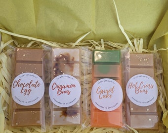 May include: Four wax melts in clear packaging, each with a different scent: Chocolate Egg, Cinnamon Buns, Carrot Cake, and Hot Cross Buns. Each melt is labeled with the scent and "Handmade in Derbyshire".