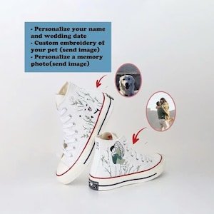 Puede incluir: Un par de zapatillas altas de lona blancas con bordado personalizado. Un zapato presenta una pareja abrazándose en un campo de hierba, mientras que el otro zapato tiene el retrato de un perro. El texto "R&C" es visible en el zapato con la pareja.