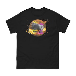 Puede incluir: Camiseta negra con un gráfico de un gorila en un círculo naranja fuego. El texto "LEGALIZE ANABOLIC STEROIDS" está escrito en letras rosas y moradas alrededor del gorila.