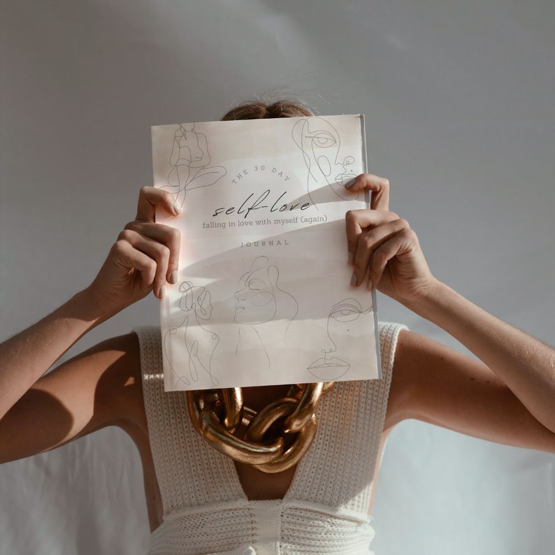 May include: A white journal with the text "THE 30 DAY self-love falling in love with myself (again) JOURNAL" on the cover. The journal has line drawings of faces on the cover.