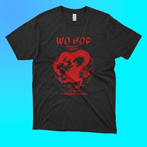 以下が含まれることがあります： 赤いドラゴンと「Wo Hop Restaurant Chinatown 17 Mott Street, New York」の文字がプリントされた黒いTシャツ