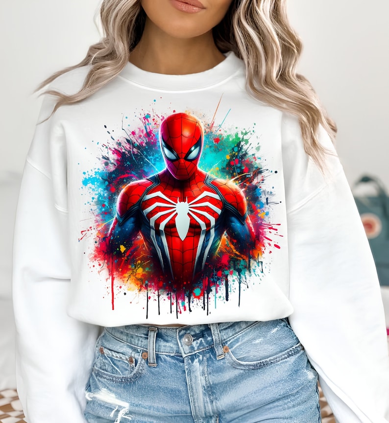 Puede incluir: Sudadera blanca recortada con un dise&ntilde;o de salpicaduras de pintura de colores con un gr&aacute;fico de Spiderman rojo y azul.