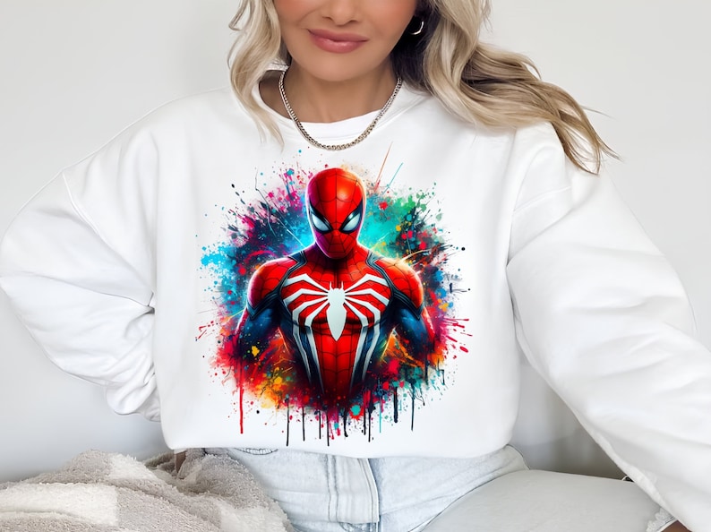 Puede incluir: Sudadera blanca con un dise&ntilde;o de salpicaduras de pintura de colores con un personaje de Spiderman rojo y azul.