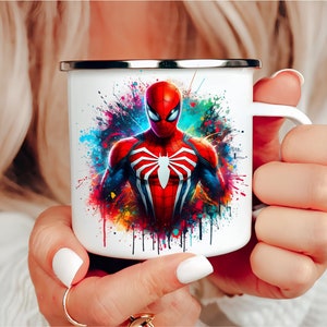 Puede incluir: Taza de esmalte blanco con un dise&ntilde;o de salpicaduras de pintura colorido con un personaje de Spiderman rojo y azul.