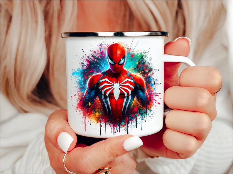 Puede incluir: Taza de esmalte blanco con un dise&ntilde;o de salpicaduras de pintura colorido con un personaje de Spiderman rojo y azul.